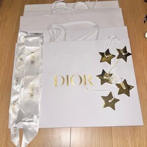 Dior white pebble shopping bags with ribbons and gold Dior stars